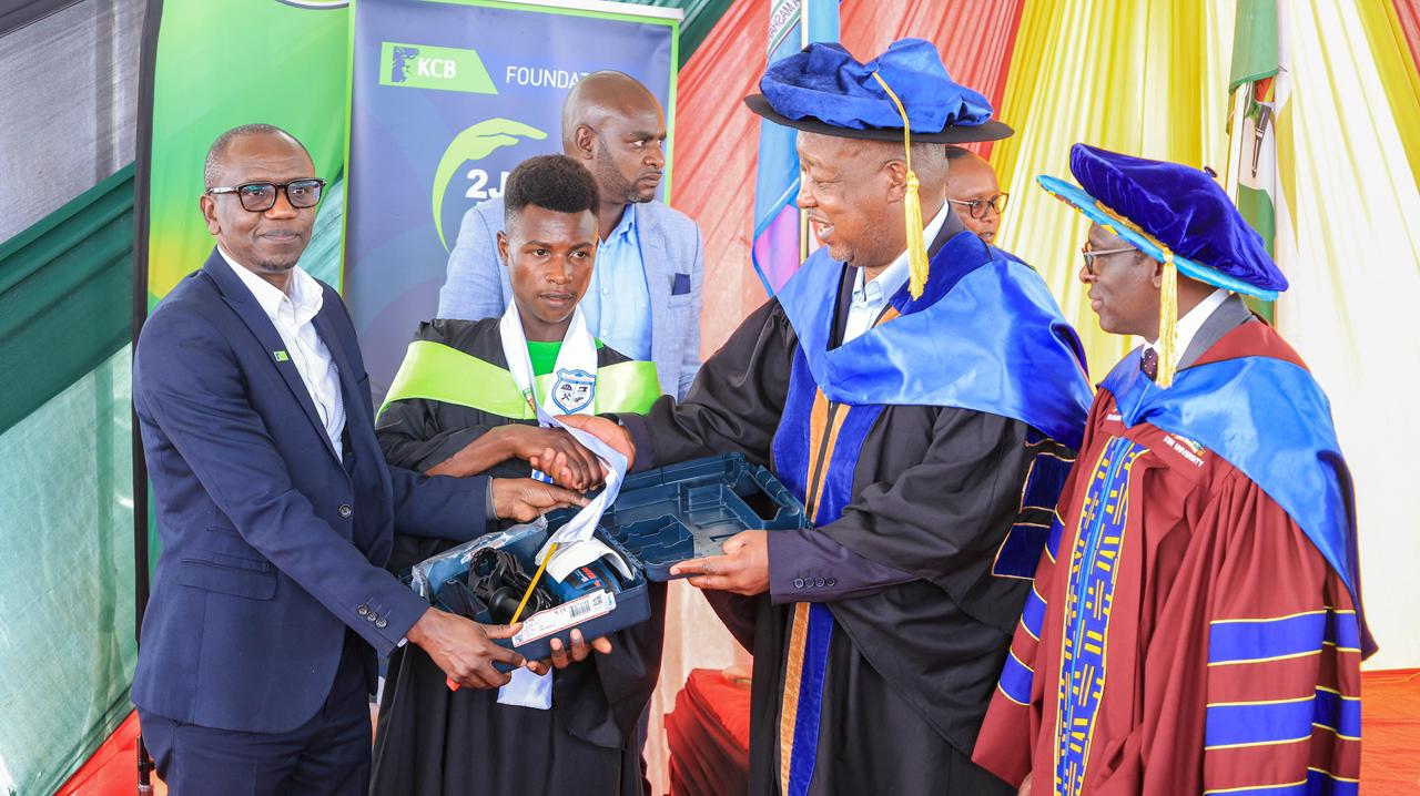 An electrical engineer graduate (second left) receiving a tool kit courtesy of KCB foundation from Governor Amos Nyaribo (second right) and KCB Foundation 2jiajiri Programmes Manager Joblin Omari (left). Looking on is Kisii University Vice Chancellor Prof. Nathan Ogechi (far right) during the trainees’ graduation at Sironga grounds. Photo: Deborah Bochere.  1 Attachment