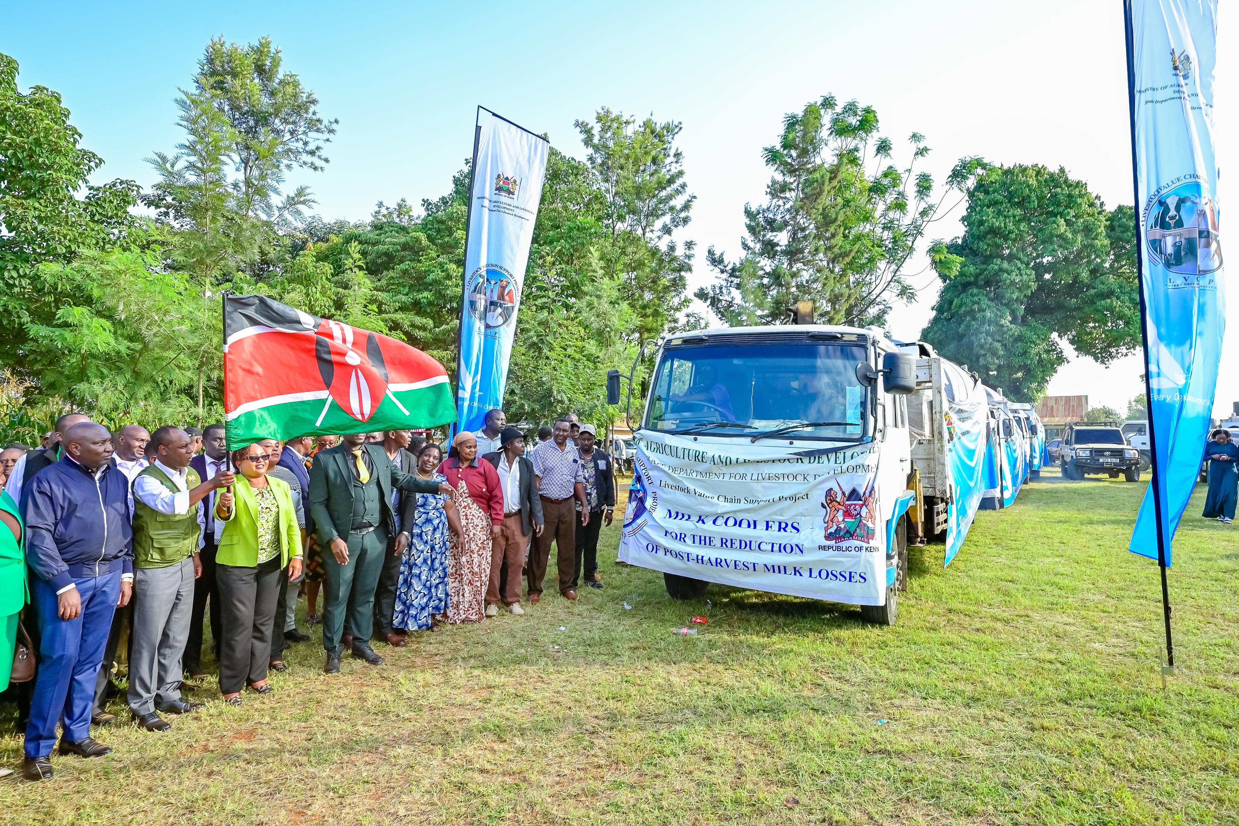 Principal Secretary for Livestock Development Jonathan Mueke (second left) and Kirinyaga County Governor Anne Waiguru (third left) flag off one of the 13 bulk milk coolers during the handover ceremony in Gichugu, Kirinyaga County.