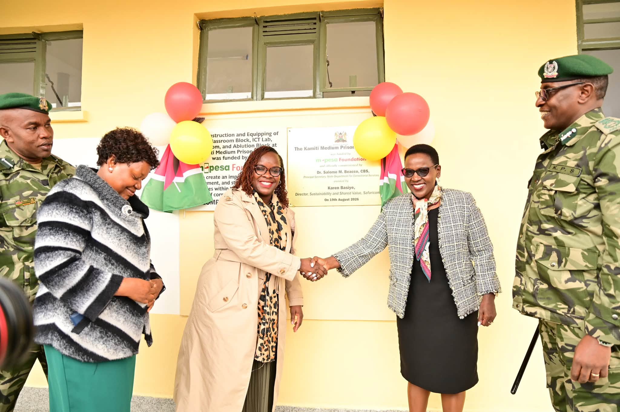 Correctional Services Principal Secretary (PS), Dr. Salome Beacco (Second Right), shares a handshake with M-Pesa Foundation Executive Director, Karen Basiye, as Commissioner General of Prisons Patrick Aranduh (Far Right), looks on during launch of the new tuition block at the Kamiti Medium Security Prison