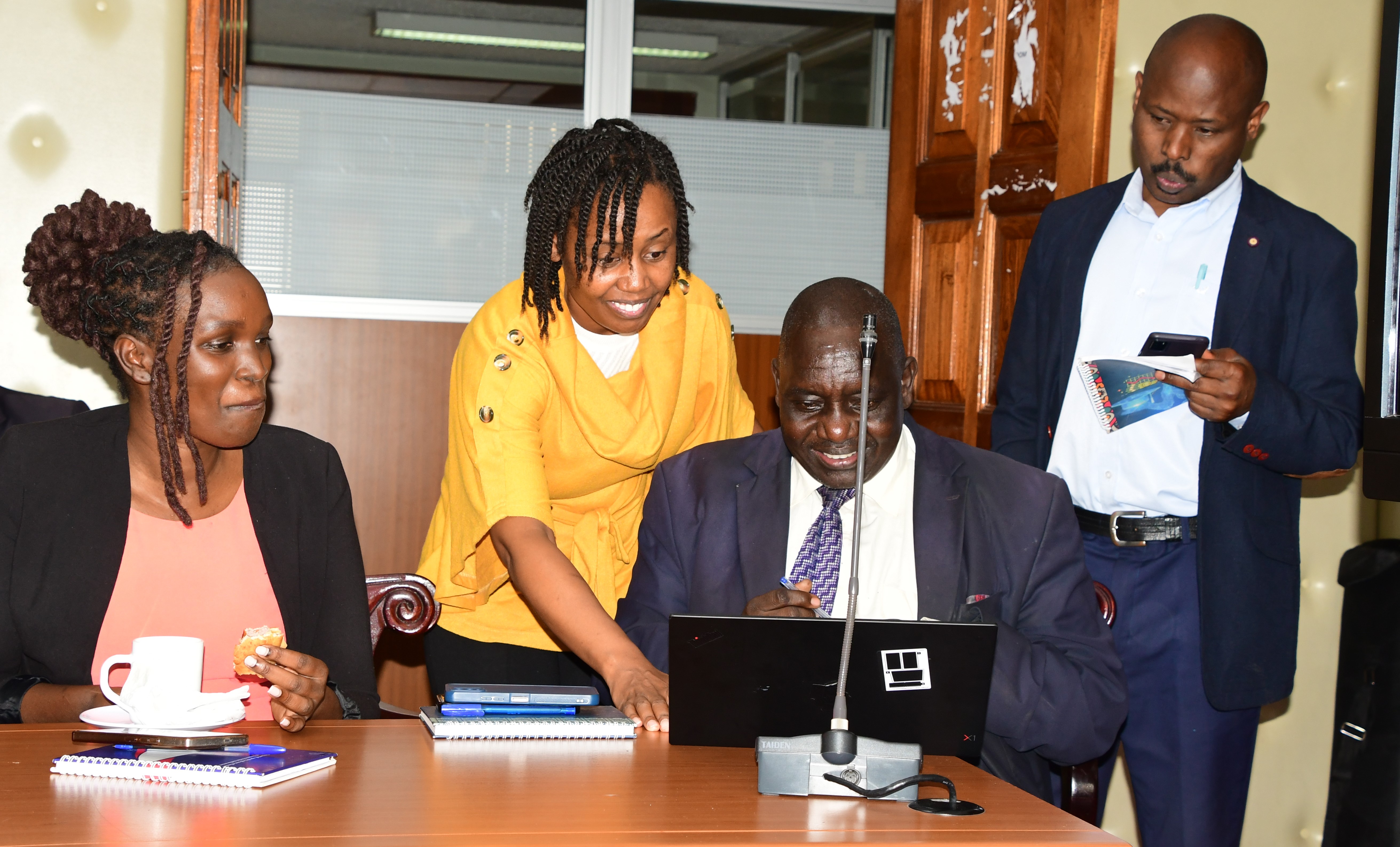 Postal Corporation strategic consultant Alice Gathoni demonstrating to the Director of Information, Joseph Kipkoech how to download the Postapay app at Teleposta Towers during the sensitization and demonstration meeting. Photo/Norah Bochere