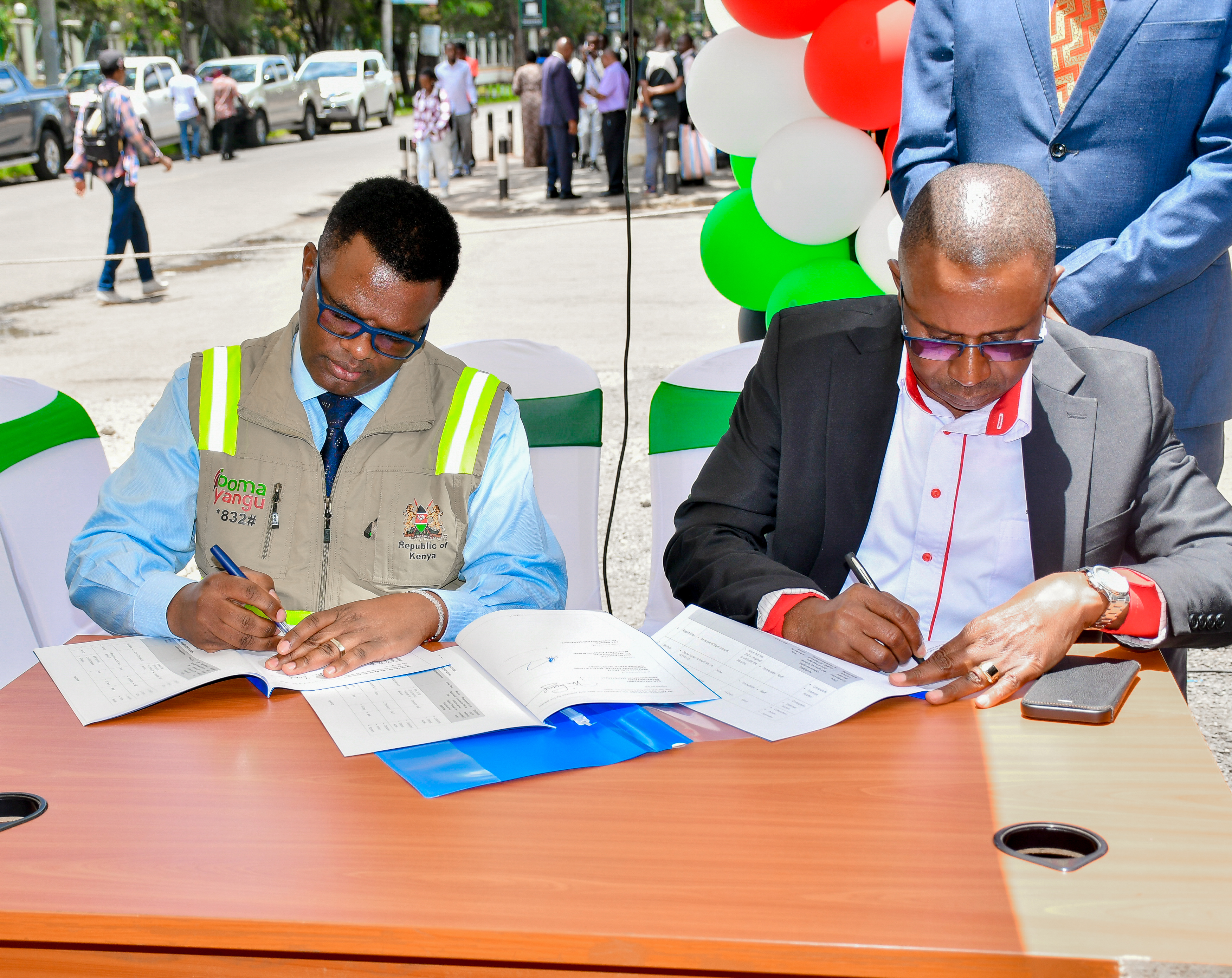 Affordable Housing Board’s Acting Chief Executive Officer Joseph Kagicha (left) and Huduma Kenya CEO Benjamin Kai Chilumo