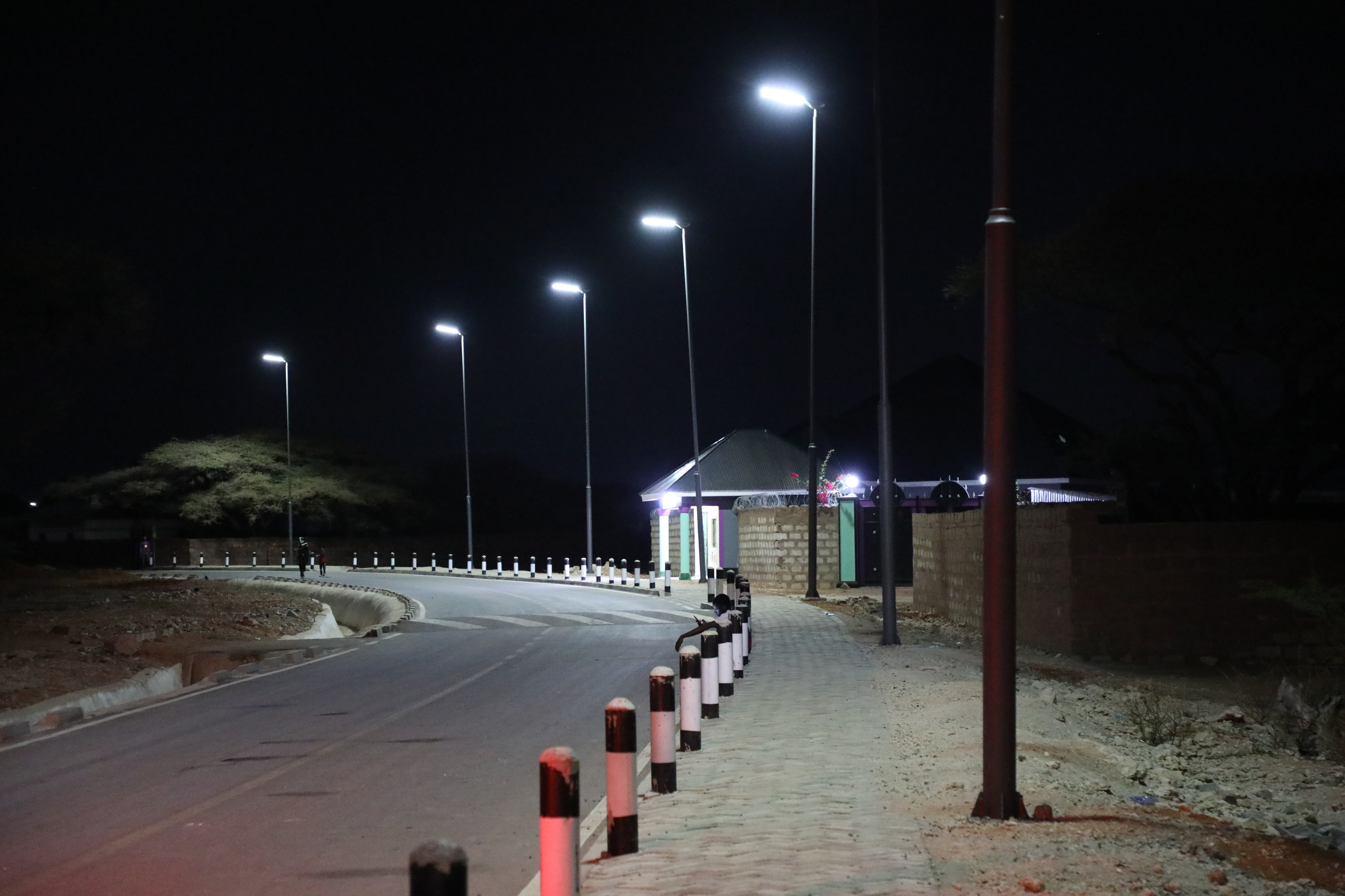 Solar-powered streetlights illuminate a road upgraded under KISIP II, improving security and extending business hours in Wajir Municipality.