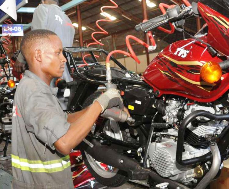 Brian Ouma refurbishing an old motor-cycle at his garage in Mamboleo area in Kisumu.