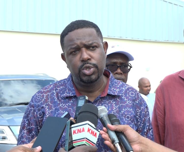 Investment Promotion Principal Secretary Abubakar Hassan Abubakar addresses journalists after the official opening of the Milly Fruit Processing Factory in Sabaki Ward of Magarini Constituency, Kilifi County. He is flanked by Kilifi County Governor Gideon Mung’aro.