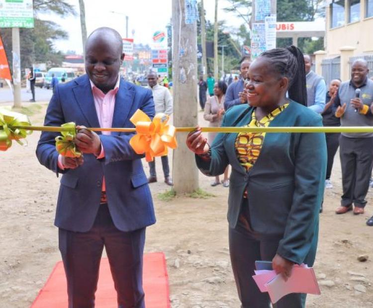 Narok County, Deputy Governor, Tamalinye Koech (left) cuts ribbon to officially open the Insurance Open Day at the William Ole Ntimama Stadium as Insurance Regulatory Authority, Corporate Communications and PR Deputy Director, Joanne Wanjala (right) looks on.