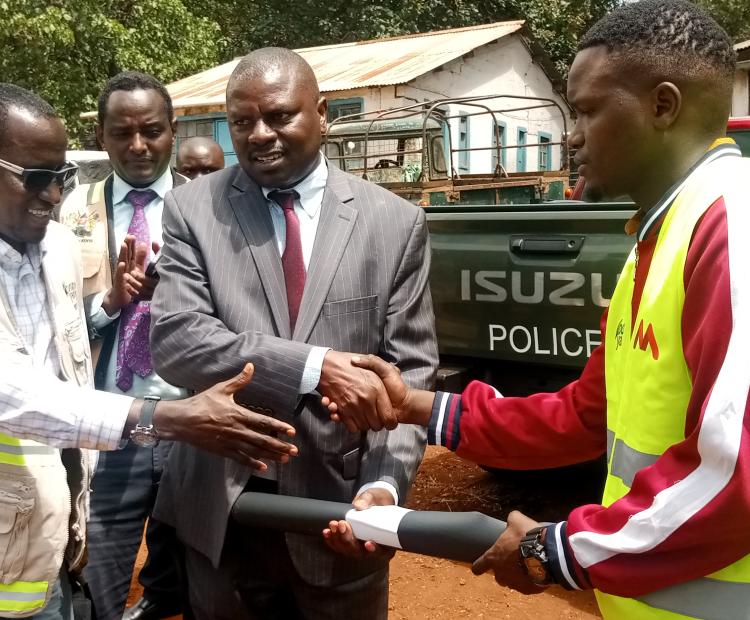 An official from Mankos Agencies Limited, Eng. Dennis Korir, receives An official from Mankos Agencies Limited, Eng. Dennis Korir (Right), receives construction site documents for the affordable housing project in Marsabit town from County Commissioner Stanley Kamande (Centre). .PHOTO: SEBASTIAN MIRITI