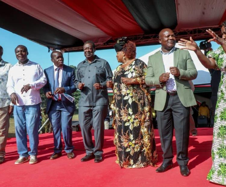 Prime Cabinet Secretary Musalia Mudavadi and CS Diaspora Affairs (middle), Kakamega County Governor Fernandes Barasa (second right) and other senior government officials jig during the launch of the second disbursement of the National Youth Opportunities Towards Advancement (NYOTA) Programme in Kakamega town. (Photo by Cypron Esolio, KNA)